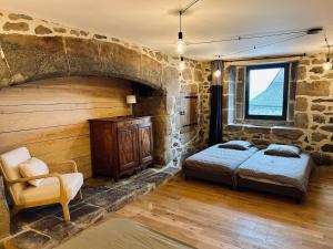 een slaapkamer met een bed en een stenen muur bij Maison cosy avec sauna en montagne in Saint-Jacques-des-Blats