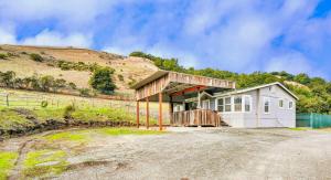 une petite maison blanche avec une colline en arrière-plan dans l'établissement Scape to the Ranch - Relax, Work or Explore, à Castro Valley