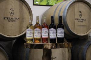 a group of wine bottles sitting on barrels at Stepanyans' Guest House in Areni +7 photos
