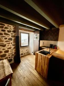 een keuken met een aanrecht en een raam in een kamer bij Maison cosy avec sauna en montagne in Saint-Jacques-des-Blats