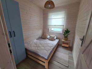 a small bedroom with a bed in a room at Domki letniskowe Pastelowe Ustronie in Ustronie Morskie +34 photos