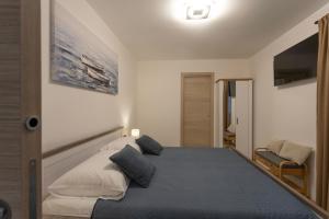 ein Schlafzimmer mit einem Bett und einem Fernseher an der Wand in der Unterkunft Vela Mala in Kaštela