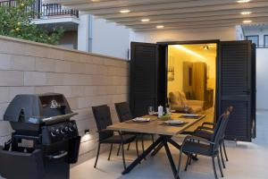 ein Tisch und Stühle und ein Grill in einem Haus in der Unterkunft Vela Mala in Kaštela + 12 Fotos