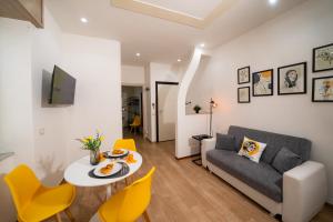 ein Wohnzimmer mit einer Couch und einem Tisch und Stühlen in der Unterkunft Casa Penelope Lucrino in Pozzuoli