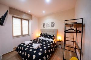 ein Schlafzimmer mit einem schwarz-weißen Bett und einem Regal in der Unterkunft Casa Penelope Lucrino in Pozzuoli
