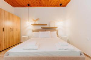 a bedroom with a large white bed with two white towels at Nikolaidis Villa Family Friendly in Nea Kallikrateia