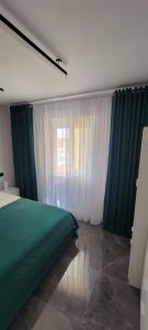 a bedroom with a green bed and a window at Sol Del Mar in Benicarló
