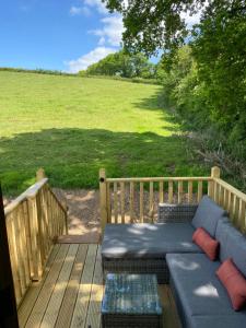 a porch with a couch on a deck with a field at Harrys Hideaway in Colyton