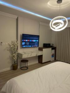 a bedroom with a bed and a large screen tv at استديو دخول ذاتي konya 3 in Jeddah