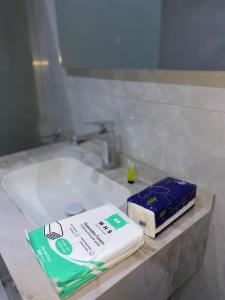 a bathroom sink with a package of toothpaste and a box of tooth paste at استديو دخول ذاتي konya 3 in Jeddah