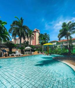 Una piscina con un complejo turístico al fondo en Hot Springs Hotel - Suítes com Banheira, en Caldas Novas