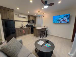 a living room with a couch and a table and a kitchen at San Pedro Belize La Casa Chiqui in San Pedro
