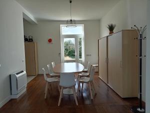 a dining room with a white table and chairs at Ancienne Poste de Montcaret in Montcaret