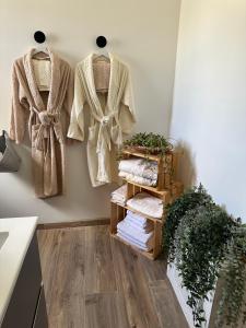 a room with three coats hanging on a wall at La Maison Belle Étoile in Limoux