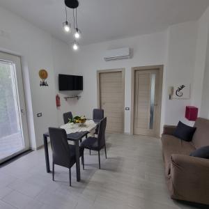 a living room with a table and chairs and a couch at CASA VACANZE - Anna Holiday Home in Tramonti +15 photos