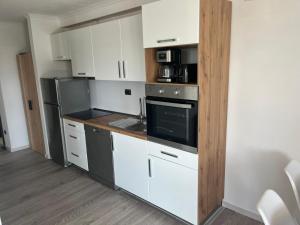 a kitchen with white cabinets and a stove top oven at Apartman Ante in Neum +10 photos