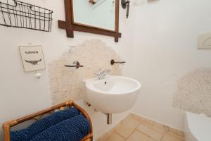 a bathroom with a sink and a mirror at Trulli Oiseaux Migrateurs in Ceglie Messapica +68 photos