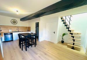 a kitchen and dining room with a table and a staircase at Maison en pierre La Sauve in La Sauve-Majeure