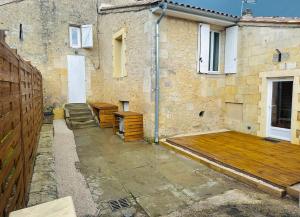 a building with a wooden deck in front of it at Maison en pierre La Sauve in La Sauve-Majeure