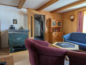 a living room with a blue couch and a table at Casa Letizia in Breil/Brigels