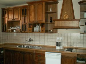 una cocina con armarios de madera y fregadero en Asso Penzion, en Bojnice