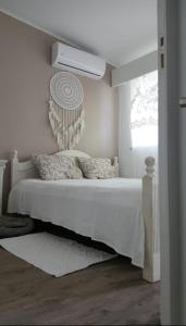 アルヴォルにあるCasa no centro Alvor- Vista Ria Alvorの白いベッドと窓のある白い寝室