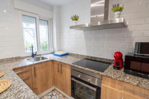 een keuken met een spoelbak en een fornuis bij Casa nueva en el Centro in Santander