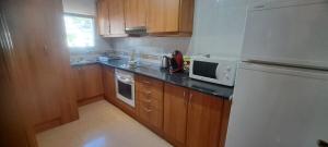 a kitchen with a white refrigerator and a microwave at Jordi's Flat close to the Beach in L'Estartit