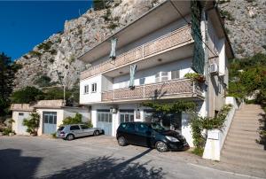un edificio con due auto parcheggiate di fronte di Apartment Renko a Omiš (Almissa)