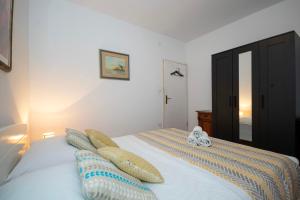 een slaapkamer met een bed met twee klokken erop bij Apartment Renko in Omiš