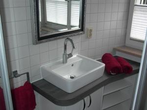 un baño con lavabo y toallas rojas en una encimera. en Studio am Neuen Schloss Meersburg, en Meersburg