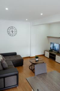 Una sala de estar con un sofá y un reloj en la pared. en StayinSetubal, en Setúbal