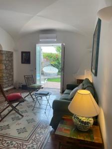 a living room with a couch and a table with a lamp at Villa La Firulina, Capri in Capri