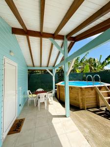 a patio with a hot tub and a table and chairs at Bunghello Village Piscine & Spa in Trois-Rivières