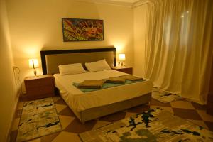 a bedroom with a bed and two lamps and a window at Villa Gem in Cairo