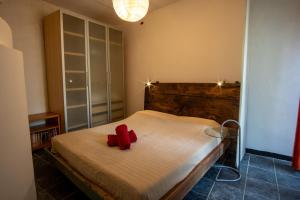 ein Schlafzimmer mit einem Bett, auf dem rote Schuhe liegen in der Unterkunft Ca' Roscia in Dolcedo