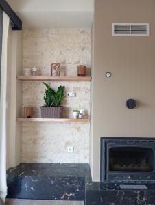a fireplace in a living room with a stone wall at Obassys View in Faraklata