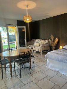 a bedroom with a bed and a table and chairs at Le Coin Charmant - vue montagnes et jacuzzi privé in Privas