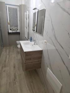 a white bathroom with a sink and a mirror at dream garden appartamento in Scafati