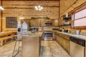 a large kitchen with wooden cabinets and appliances in a cabin at Eat, Drink and Be Beary by Avada Properties in Sevierville