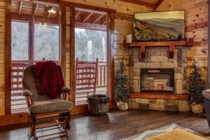a living room with a fireplace and a chair at Eat, Drink and Be Beary by Avada Properties in Sevierville