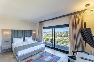 a bedroom with a bed and a large window at Bombien Luxury in Bodrum City
