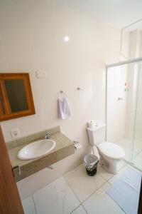 ein weißes Badezimmer mit Waschbecken und Toilette in der Unterkunft Hotel Janaína in Porto Belo