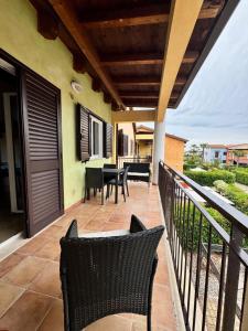Un patio con sillas y una mesa en un balcón. en Casa vacanze Le Dune, en Policoro