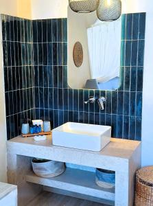 a bathroom with a sink and a mirror at Sea Side Studios & Houses in Kalo Livadi