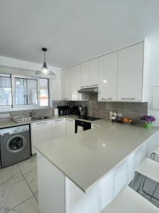 a kitchen with white cabinets and a white counter top at Sea Breeze - Oroklini in Voroklini +50 photos