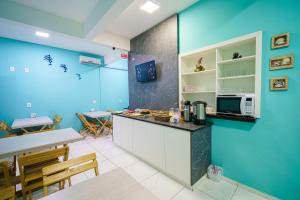 eine Küche mit blauen Wänden und einer Theke mit einer Mikrowelle in der Unterkunft Hotel Janaína in Porto Belo