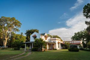 a large white house with a grass yard at Villa María, nature and relaxation in Gualeguay