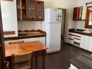 a kitchen with a table and a white refrigerator at Villa María, nature and relaxation in Gualeguay