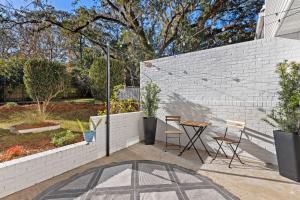 a patio with a table and chairs next to a brick wall at Private Garden Retreat | King Bed | TMH + Downtown in Perkins